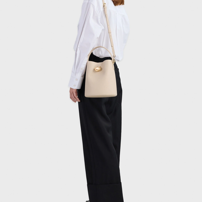 Soft Mushroom Cream Fine Grain Tapered Bucket Hand Bag With Oval Magnetic Clasp, Curved Top Grip And Detachable Slim Shoulder Strap
