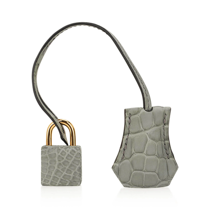 Muted Soft Concrete Grey Embossed Scaled Sharp Edged Compact Hand Tote With Luminous Golden Twist Lock Hardware And Matching Grey Suspended Metal Padlock Charm